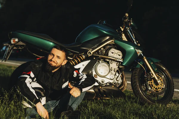 Caucasiano Jovem Barbudo Motociclista Sentado Descansando Chão Encostado Sua Motocicleta — Fotografia de Stock