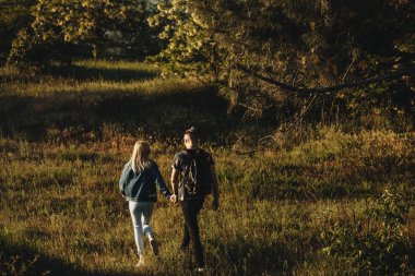 Arkadan görünüşü yürüme onların tatil süresi seyahat ve onların elele tarafından bir sevimli genç çift.
