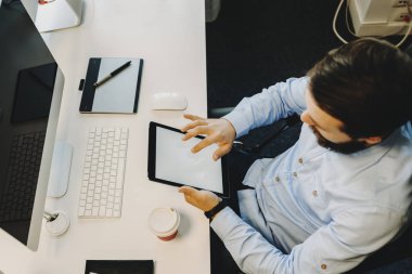 Tablet bilgisayar ile masa başında oturan kullanma erkek yukarıdan görüntülemek 