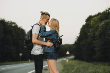 Genç adam ve kucaklayan ve burun kırsal yolculuk sırasında yol kenarında üzerinde dururken dokunmadan kadın yan görünüm