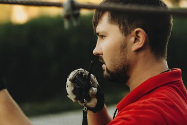 Yetişkin sakallı adam cidden dış görev ve çalışma bakarken Taşınabilir verici konuşma yan görünüm 