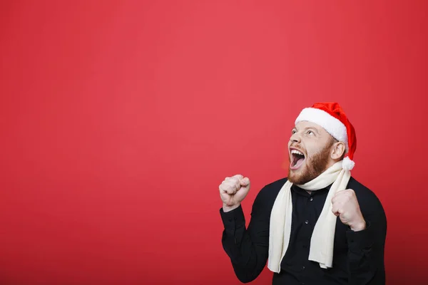 Jóképű Srác Karácsonyi Kalapban Zúgó Állva Világos Piros Háttérben Ünnepeljük — Stock Fotó