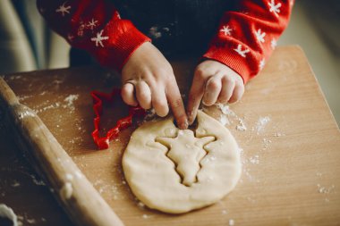 Anonim çocuk kesme ağaç şeklinde Bisküvi pasta Noel için mutfakta hazırlanırken yumuşak hamur atış yukarıdan