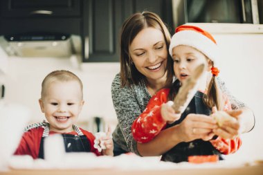 Annesi ve kız kardeşi Noel tatil hazırlanma mutfakta kurabiye yapma ile heyecanlı yürümeye başlayan çocuk