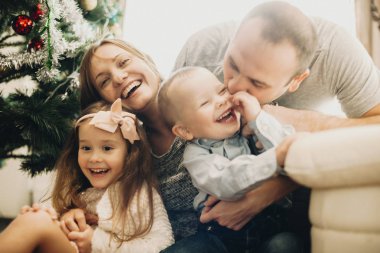 Mutlu ailesi birbirlerine ve başlatma Noel ağacı yakınındaki kucaklayan