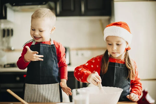 可爱的小男孩微笑着 看着肮脏的手 同时帮助姐姐煮美味的糕点为圣诞节庆祝 — 图库照片