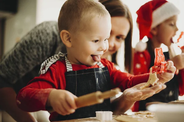 模糊的女性帮助可爱的男孩可爱的圣诞饼干从柔软的面团 而在家里一起做饭 — 图库照片