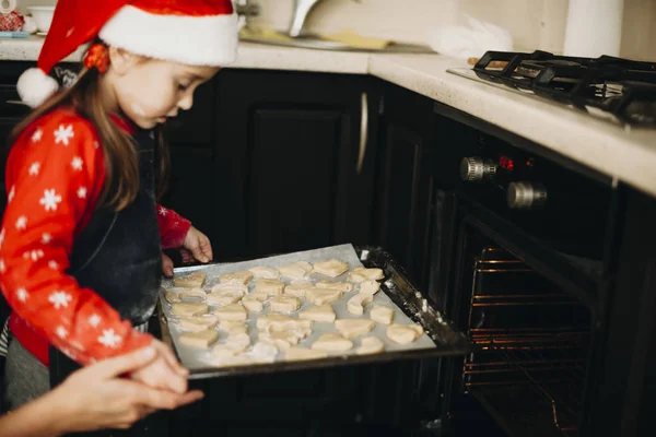 Vista Lateral Mano Ayudando Niña Poner Galletas Navidad Horno —  Fotos de Stock