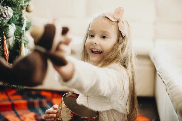 Маленькая Взволнованная Девушка Открывает Коробку Показывает Плюшевого Мишку Сидящего Полу — стоковое фото
