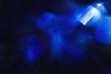 Parlak mavi ışık parlayan siyah arka plan üzerine bulanık yuvarlak lekeleri closeup çekim