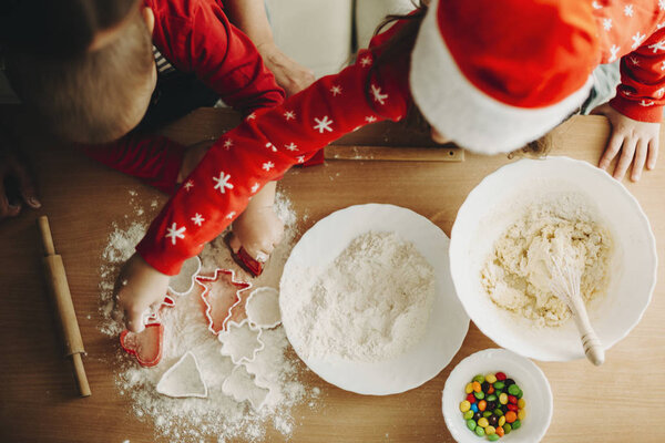 From above shot of children with cutters making cookies for Xmas holiday at table