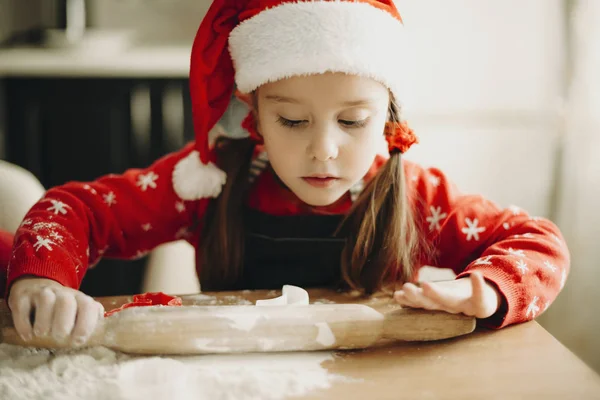 Adorable Chica Concentrada Con Sombrero Santa Sentado Con Rodillo Mesa —  Fotos de Stock