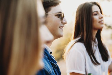 Gülümseyen ve uzak duran arkadaşlar yakınındaki kırsal kesimde seyir şık gözlüklü çekici adam yan görünüm