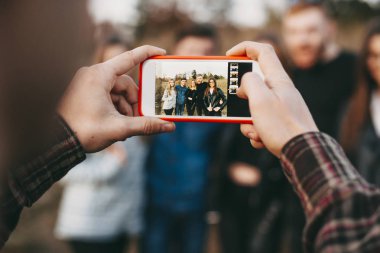 Eller anonim erkek fotoğraf genç arkadaşlar grubunun doğada çekmek için smartphone kullanarak