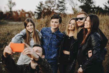 Sarılma ve muhteşem kırsal kesimde selfie çekerken gülümseyen genç arkadaş grubu