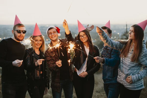 Grupo Jovens Homens Mulheres Sorrindo Segurando Faíscas Ardentes Enquanto Celebra — Fotografia de Stock