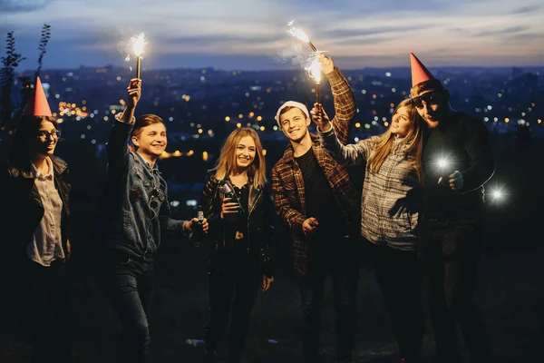 Group Young Friends Bottles Beer Bright Sparklers Smiling Looking Camera — Stock Photo, Image