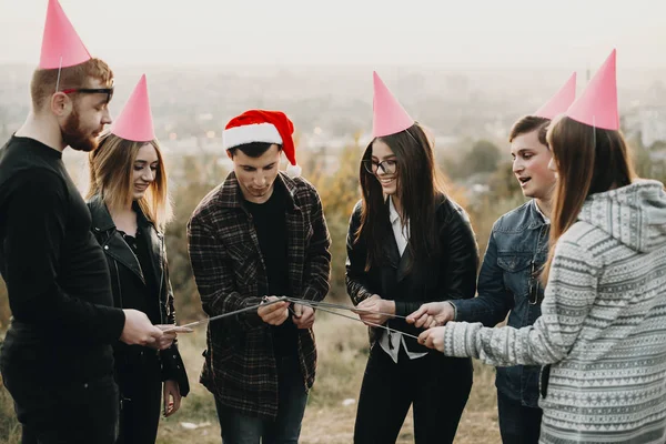 Grupo Jovens Natal Chapéus Festa Sorrindo Iluminando Faíscas Enquanto Estão — Fotografia de Stock