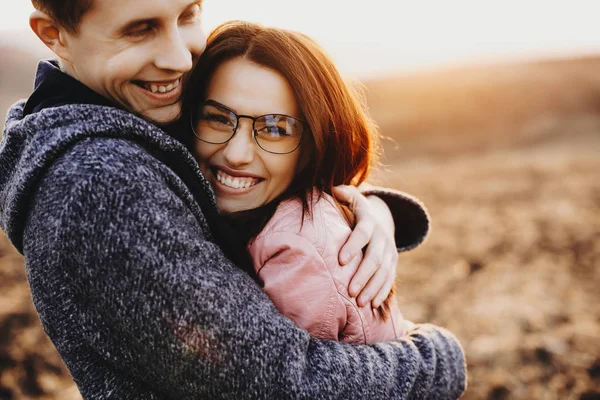 可爱的男人抱着她的女人笑着 而旅行反对日落 可爱的夫妇有乐趣在一起 — 图库照片