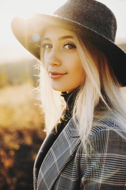 Kamera bir turist onun tatil zamanında baharda olurken günbatımı karşı bakarak güzel bir yetişkin kadın portresi.