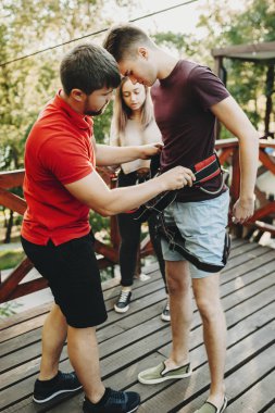 Genç sarışın beyaz adam ip slayt aşırı spor için kız arkadaşıyla tatil zamanında seyahat ederken donatılmış.