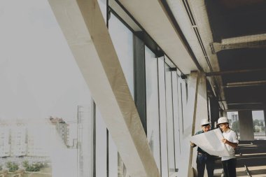 İki genç mühendis bulmak için binanın planına bakarak