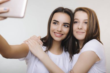 İki sevimli beyaz kız ile bir zeki bir selfie yapıyor giymiş