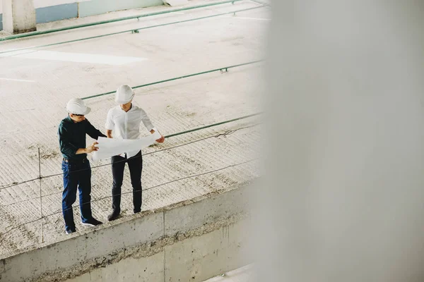 Binanın projesini araştıran iki genç mühendis 