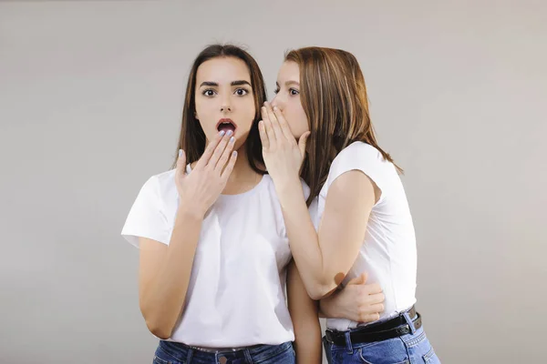 Preciosas mujeres caucásicas chismorreando al oído de su novia mientras — Foto de Stock