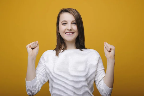 Jovem mulher alegre olhando para a câmera rindo celebrando uma vítima — Fotografia de Stock