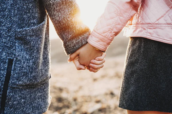 Se tenant la main d'un couple sortir ensemble à l "extérieur tout en explorant nouveau pla — Photo