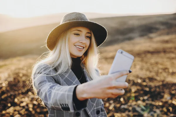 Erstaunliche blonde kaukasische Frau mit Hut macht ein Selfie mit s — Stockfoto