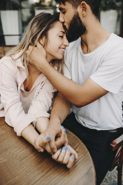 Porträt eines reizenden Paares, das in der Stadt an einem Tisch sitzt — Stockfoto