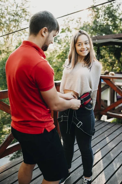 Vacker ung kvinna utrustas av en ropewayen arbetstagare samtidigt — Stockfoto