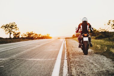 Arkadan görünüşü onun motosiklet durdurma üzerinde oturan bir donanımlı motorcu 