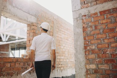 Arkadan Görünüm bir plan ile kendine güvenen genç mimar han haddelenmiş