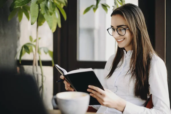 Precioso moderno caucásico femenino estudiante aprendizaje mientras mira en — Foto de Stock