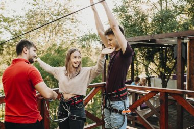 Sevimli genç çift bir zip line platformda gülerek eğlenmek ve