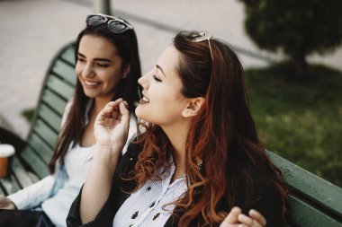 Bir bankta otururken kız arkadaşı için büyüleyici bir şey anlatan kırmızı saçlı hikaye ile inanılmaz artı boyutu kadın portresi kadar yakın.