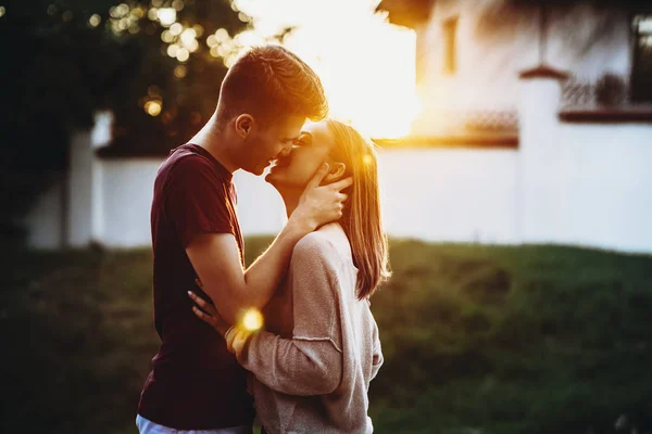 一个可爱的白种人夫妇在夕阳灯光下亲吻城堡前微笑的侧视图肖像 同时在一起 — 图库照片