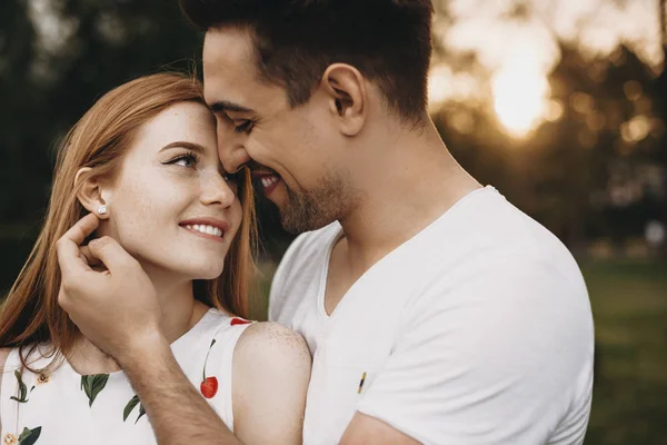 Vista lateral retrato de um belo jovem casal sorrindo enquanto loo — Fotografia de Stock