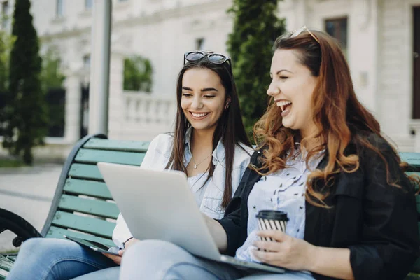 İki güzel kadın coffe içerken bir bech laughig üzerinde oturan 