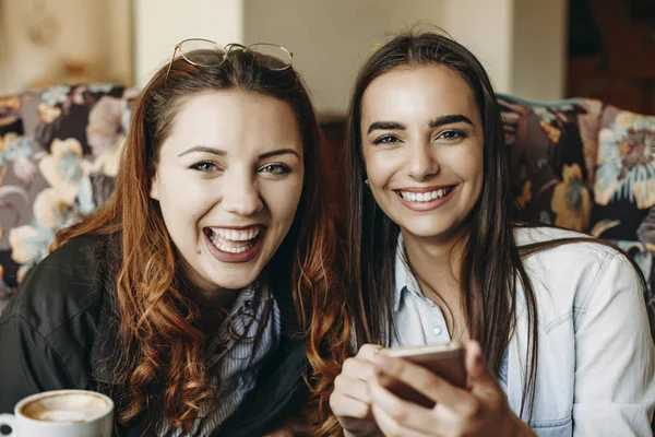 Ritratto di due belle donne che guardano la macchina fotografica ridere whil — Foto Stock