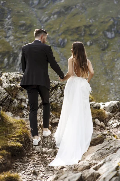전체 길이와 뒤로 보기의 젊은 결혼식 부부 걷는 목 — 스톡 사진