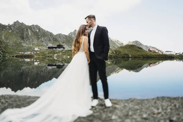 Retrato de larga duración de una pareja de boda increíble mientras el novio es —  Fotos de Stock