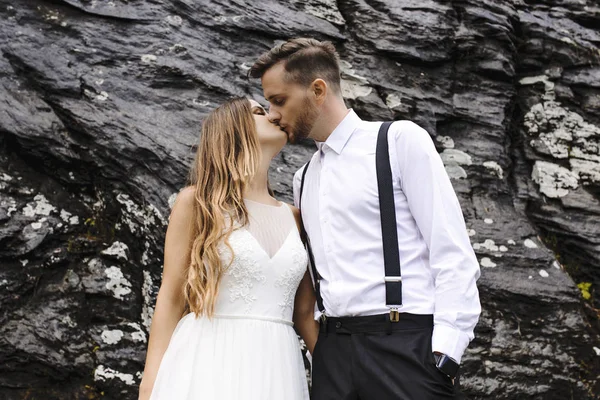 Side view portrait of a beautiful young groom and bride kissing — Stock Photo, Image