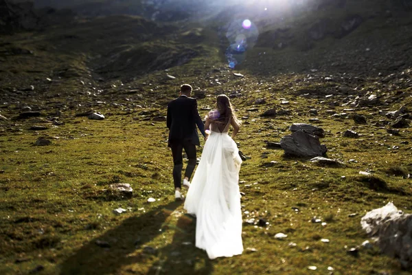 Вид ззаду на невпізнавану наречену і наречену, що біжить в му — стокове фото