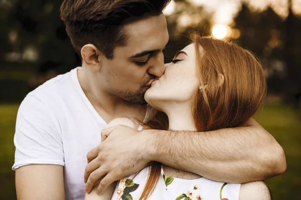 Gros plan portrait d'un jeune couple caucasien baisers contre su — Photo