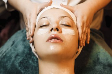 Bir kaplıcaya yaslanmış beyaz bir kadının yakın portresi 