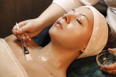 Güzel genç beyaz kadın kapalı bir spa yatağına yaslanmış